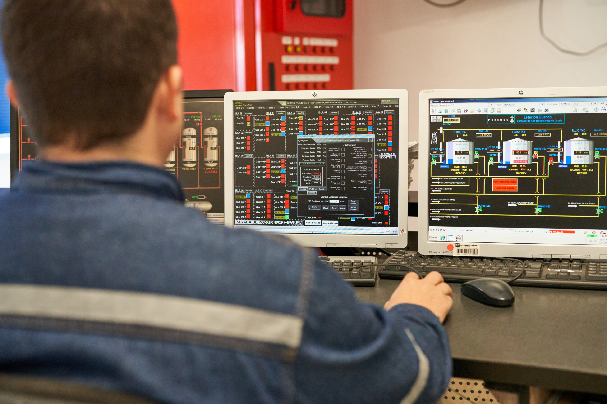 Man seen from the back working on computers in the control room onshore Colombia