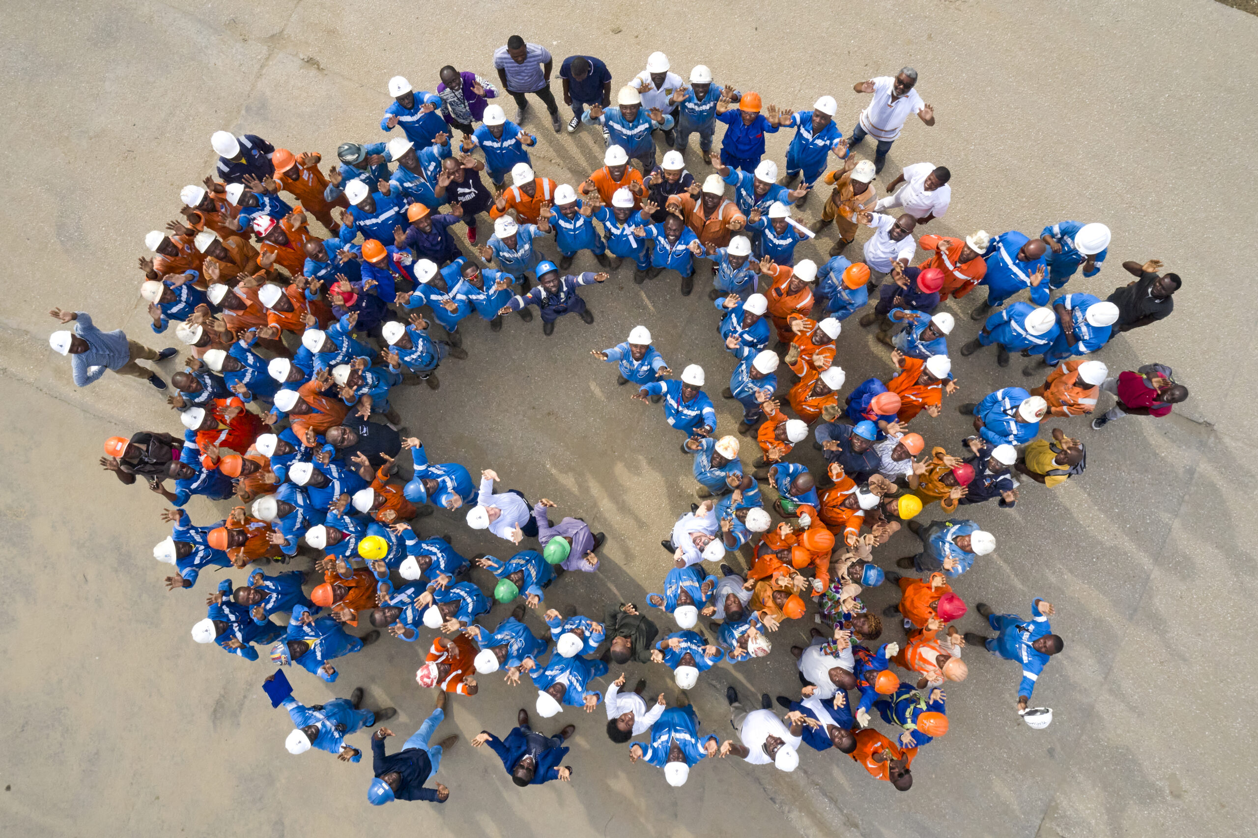 Bunch of working men looking up with hands in the air in Congo.