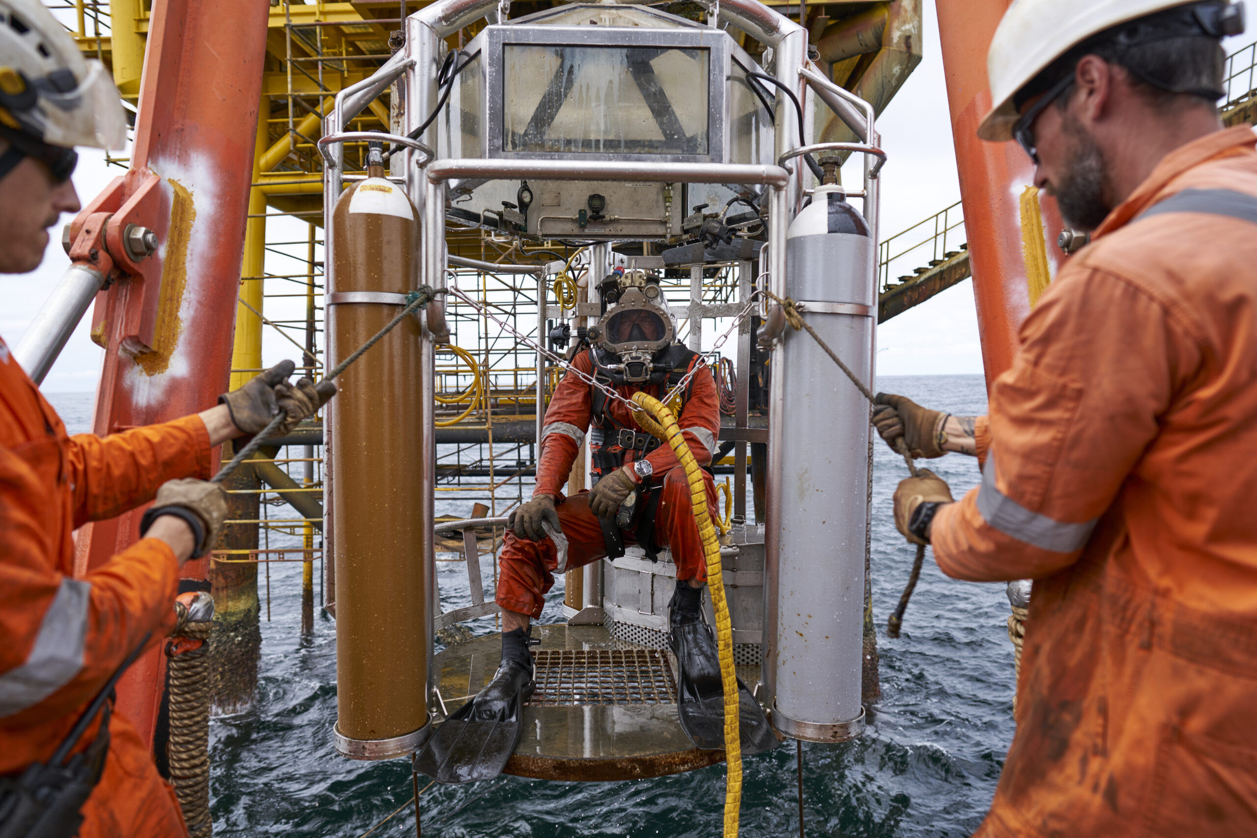 Two men supporting a diver below the platofrm offshore Congo