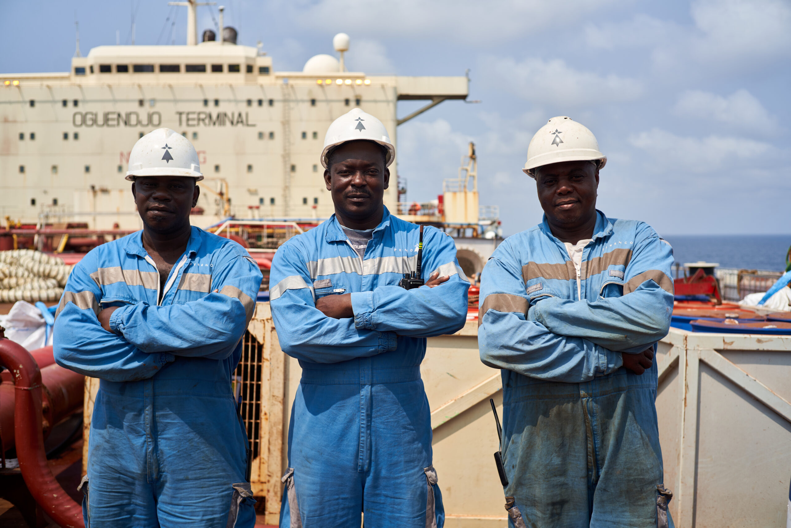 Three men crossing arms on cargo in Gabon
