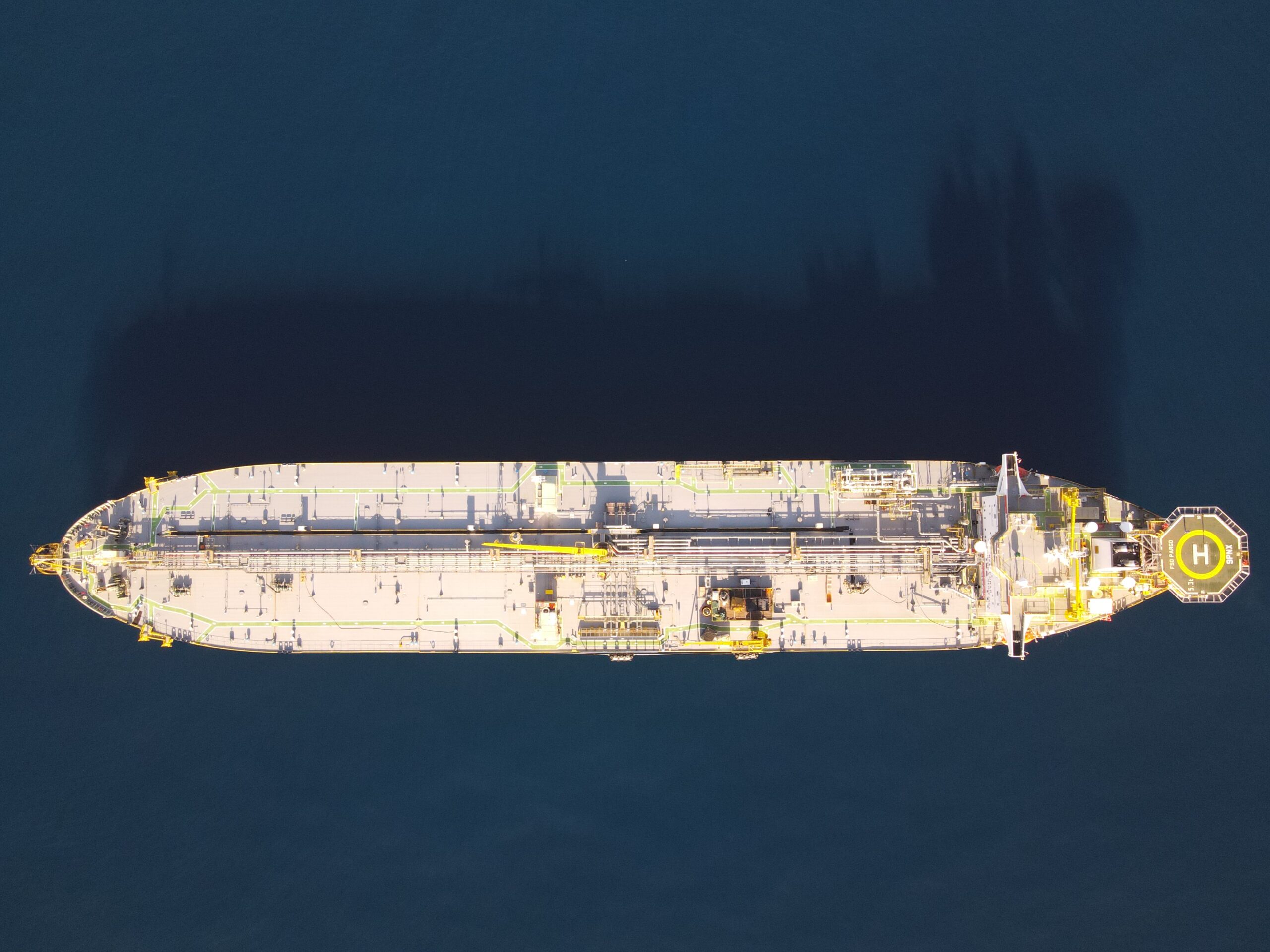 Floating long cargo boat seen from above 