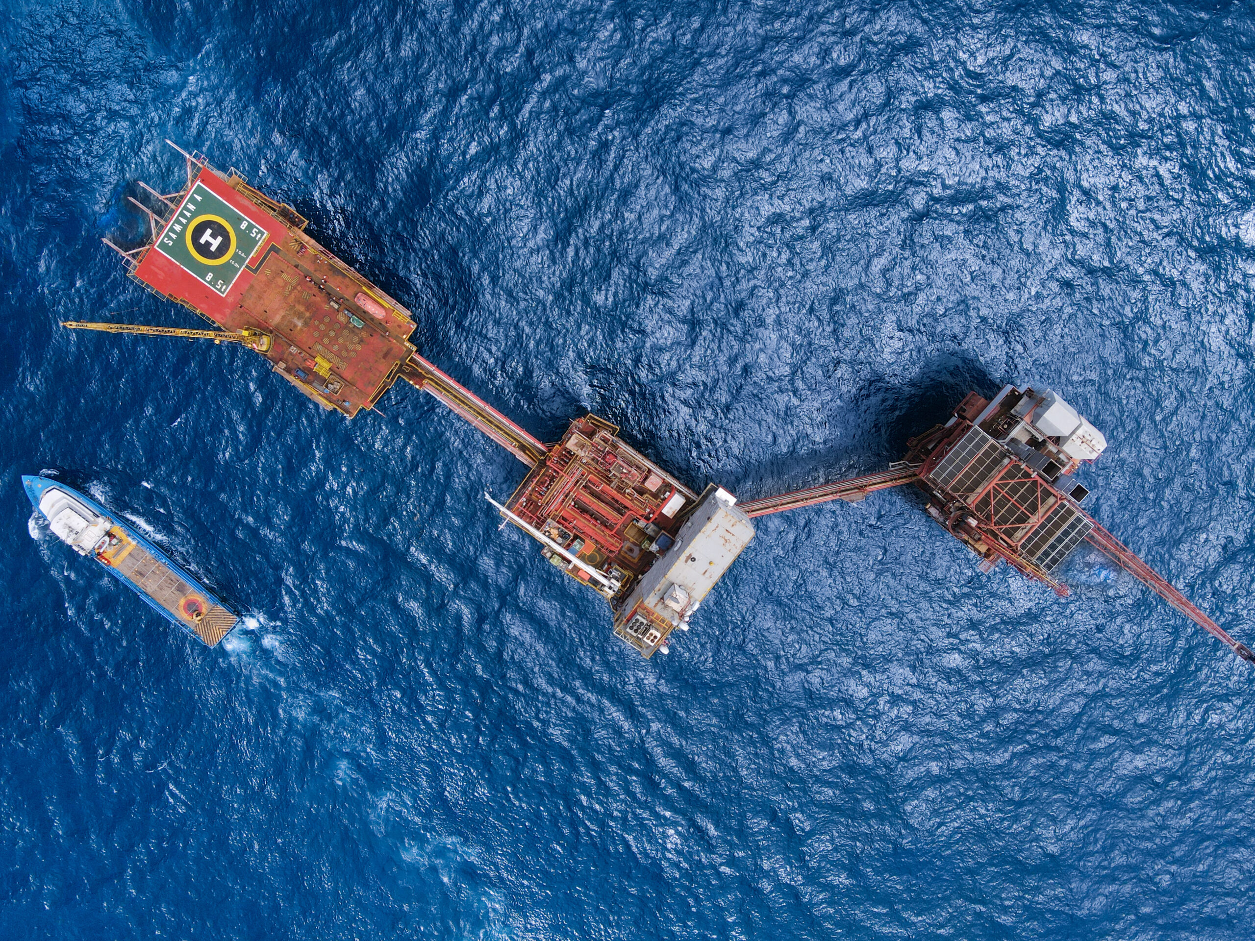 Three platforms attaching to each other and a boat seen from above in Trinidad and Tobago 